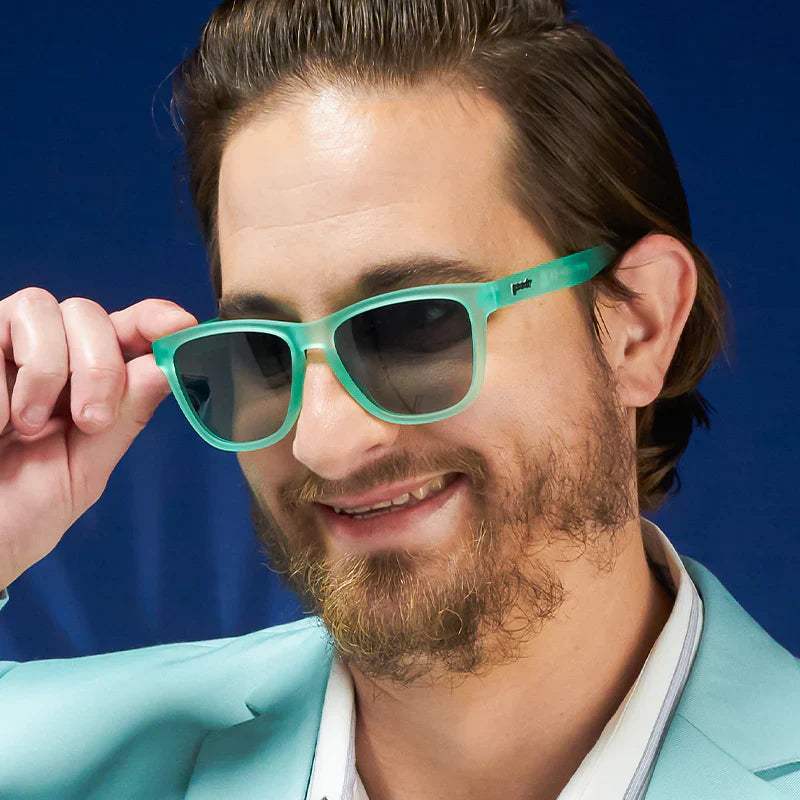 Man wearing teal sunglasses and blue blazer, associated with Dinner Mint Debauchery.