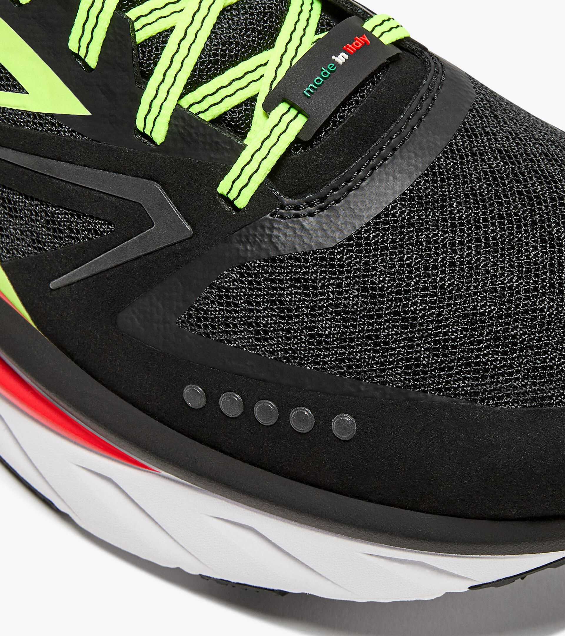 ATOMO V7000-2 running shoe with green laces and black mesh design.