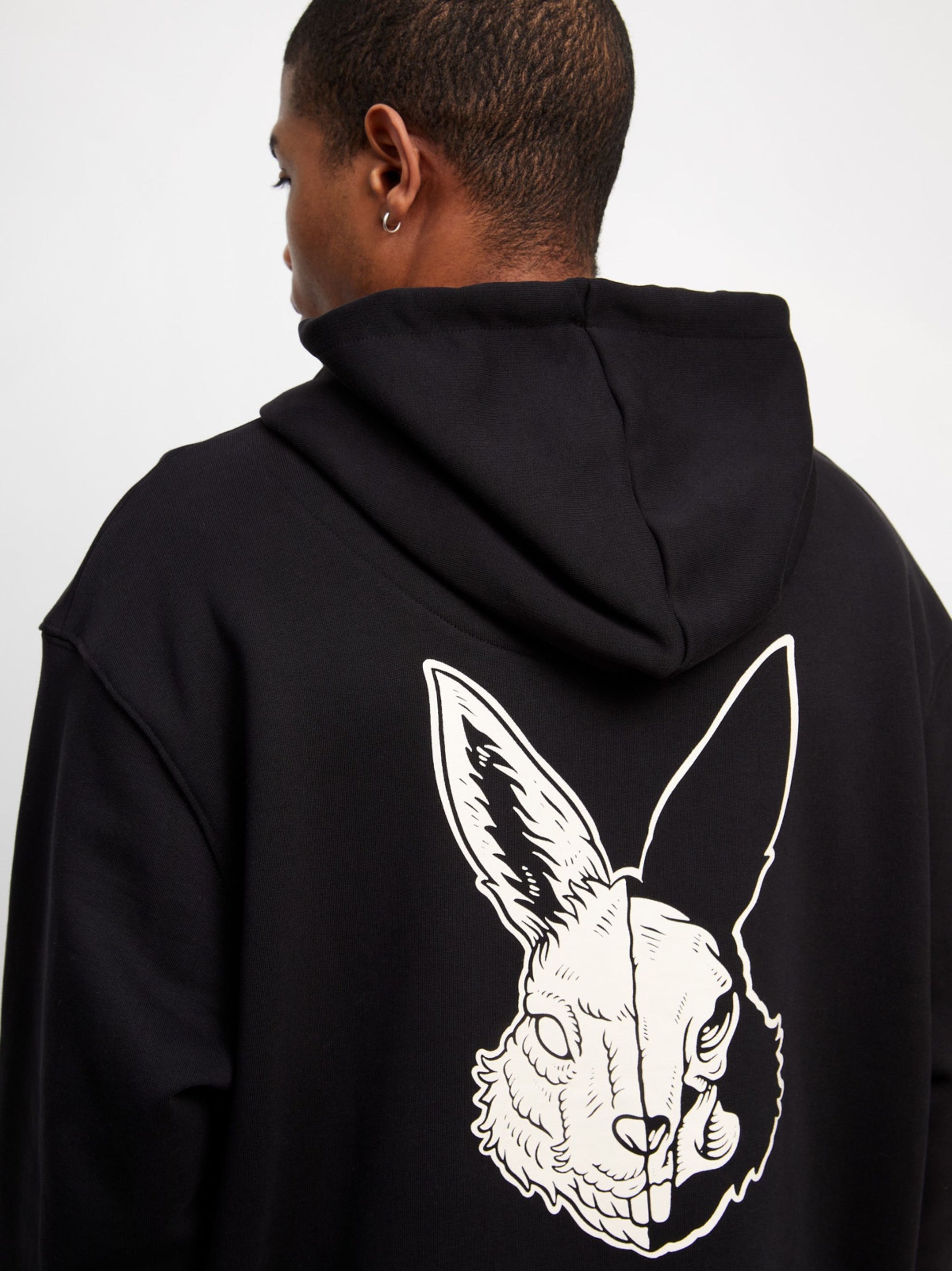 Black logo hoodie with off-white embroidery and acid hare print, made from organic cotton.
