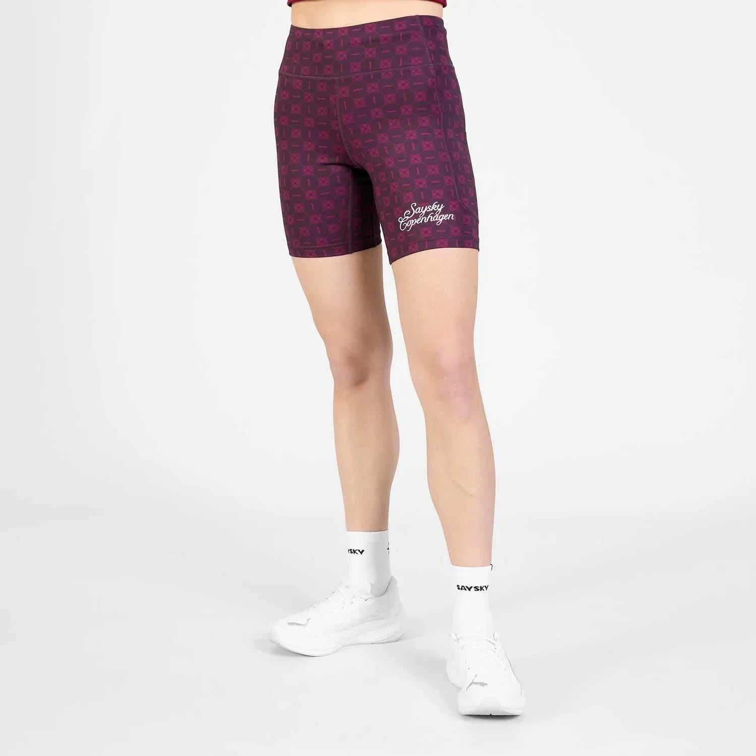Couture Combat+ short tights in dark purple with a geometric pattern, high-waisted design, and logo detail on the left thigh.