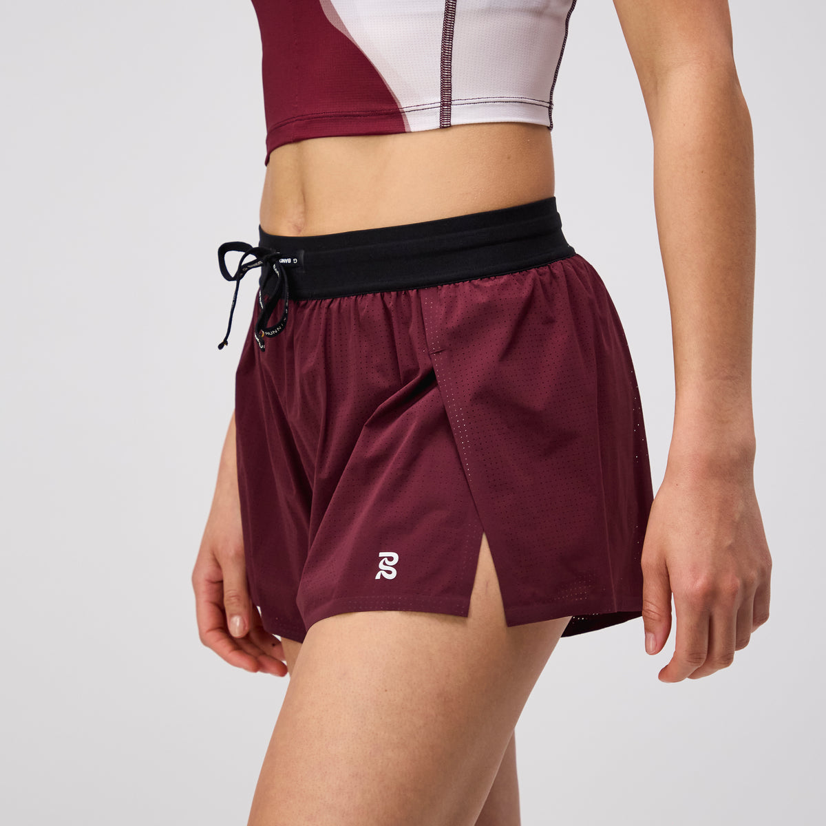 Vento™ Women's 3" Split Short in Port color featuring breathable fabric, phone pocket, and reflective logo.
