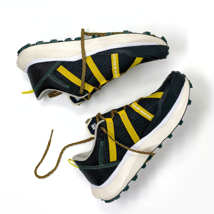 Trail running shoes "Get Lost" with a black, yellow, and white design, featuring a Vibram Litebase/Megagrip outsole, shown from the side.