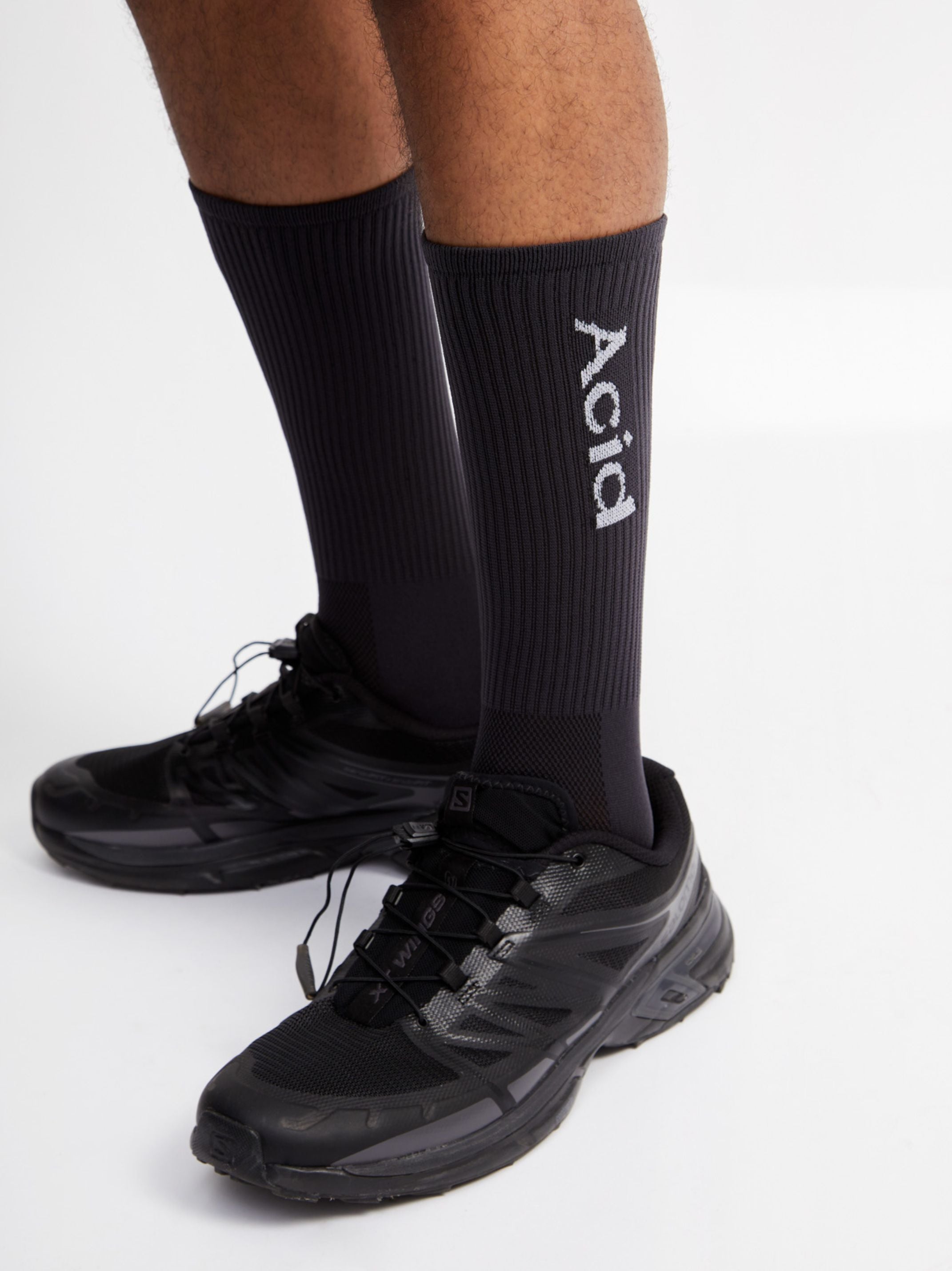 Black logo socks with ankle height, lightweight and breathable design.