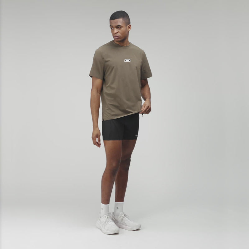 Man wearing MicroGrid™ Proto Tee in Dark Fatigue, featuring crew neckline and silicone patch, designed for performance and comfort.