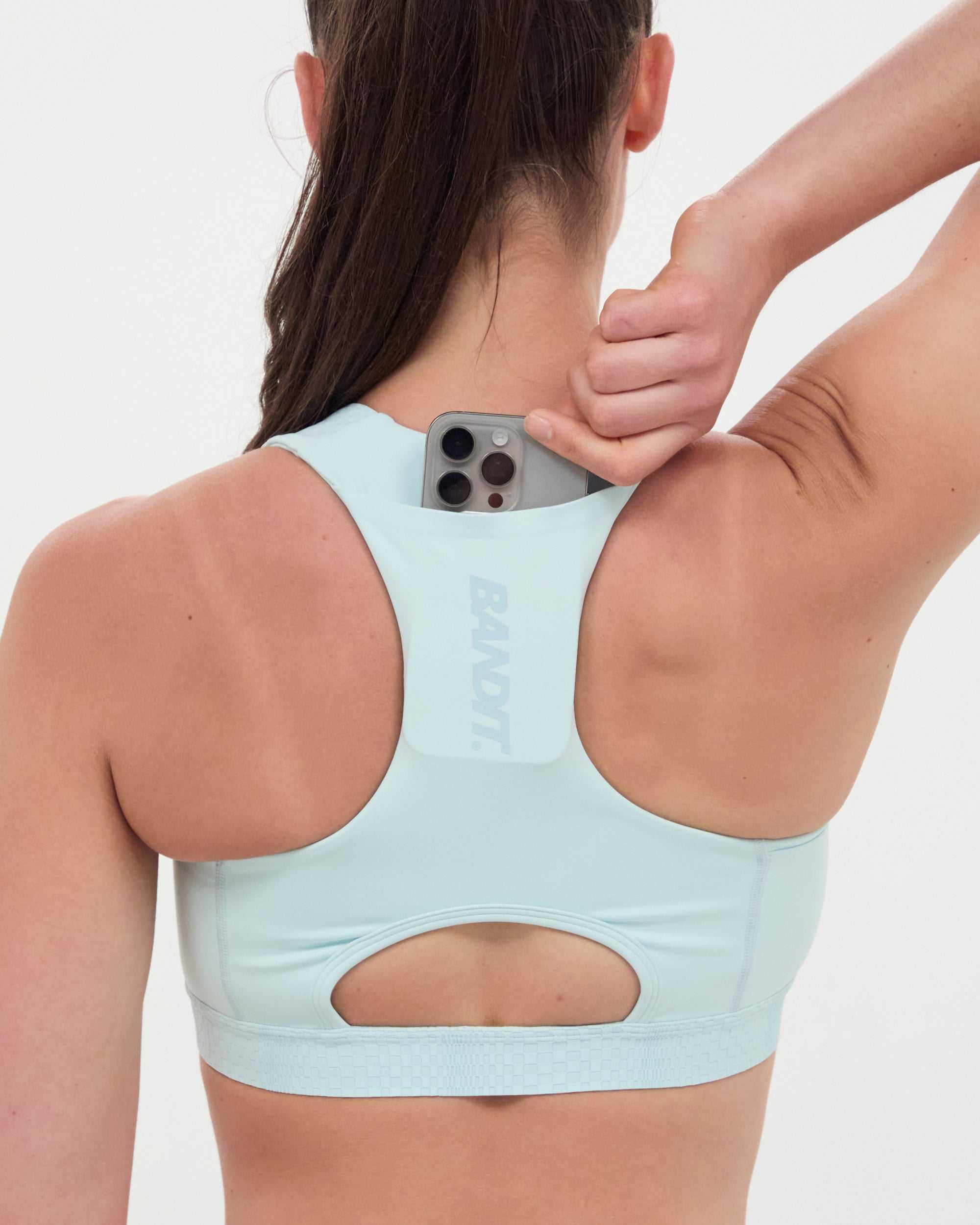 Minty blue Stamina™ Scoop Neck Run Bra with pocketing system and reflective details.