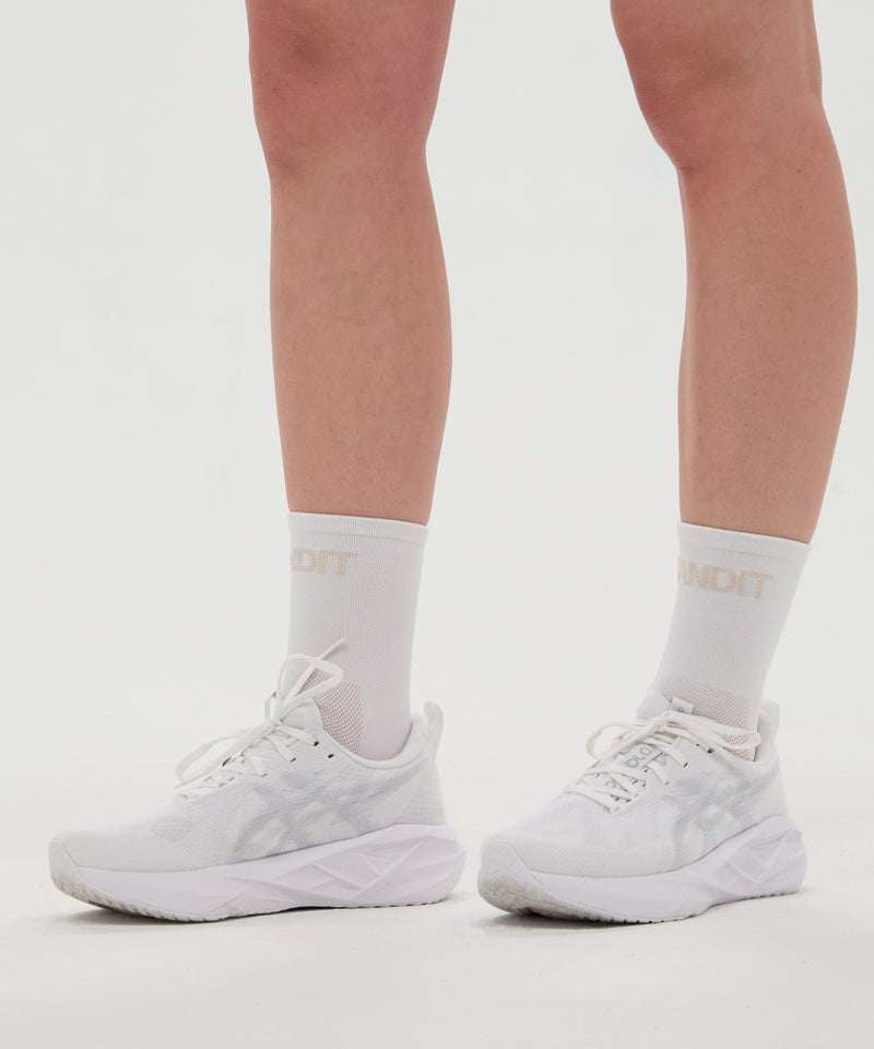 White and cocoa Lite Run™ Socks on feet, showcasing lightweight design and branded embroidery.