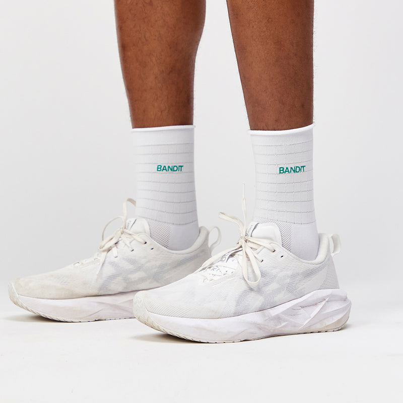 White Grid Knit™ Socks with Gulfstream detail, featuring COOLMAX yarn and embroidered branding, displayed on person wearing white athletic shoes.