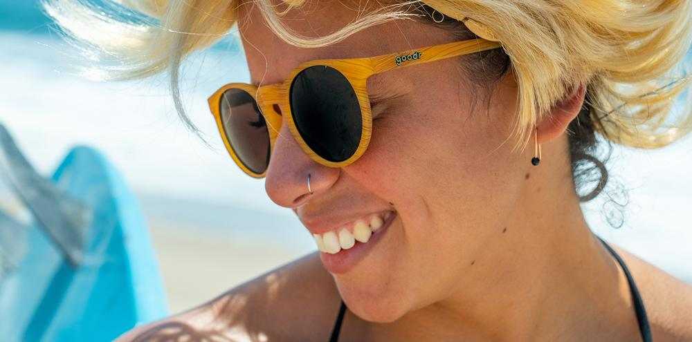 Bodhi' Ultimate Ride sunglasses on person at the beach.