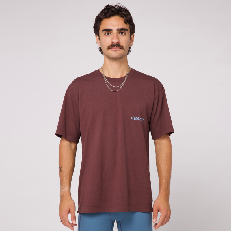 Community Tee Unisex - Chocolate with Smokey Blue print, featuring a relaxed fit and crew neckline, made from 100% combed cotton.