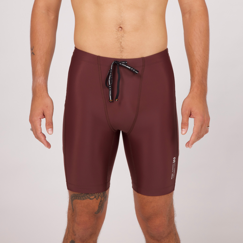 Superbeam half tights in chocolate color with seven pockets, grip tape, and reflective branding.