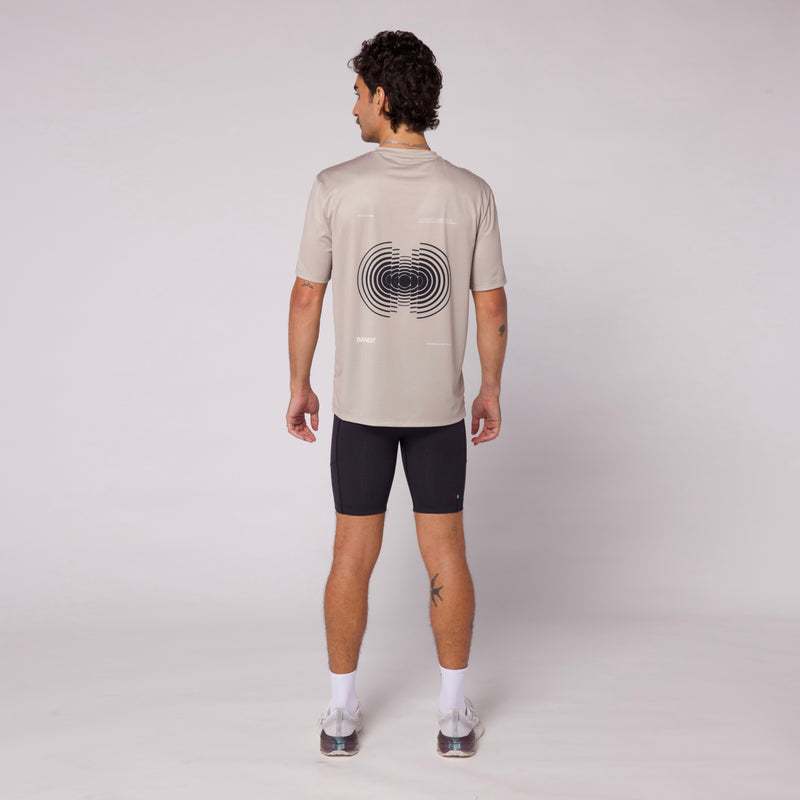 Back view of the Sliced Spiral Drift™ Performance Tee in stone color with a seasonal graphic design, exemplifying lightweight and breathable athletic wear.