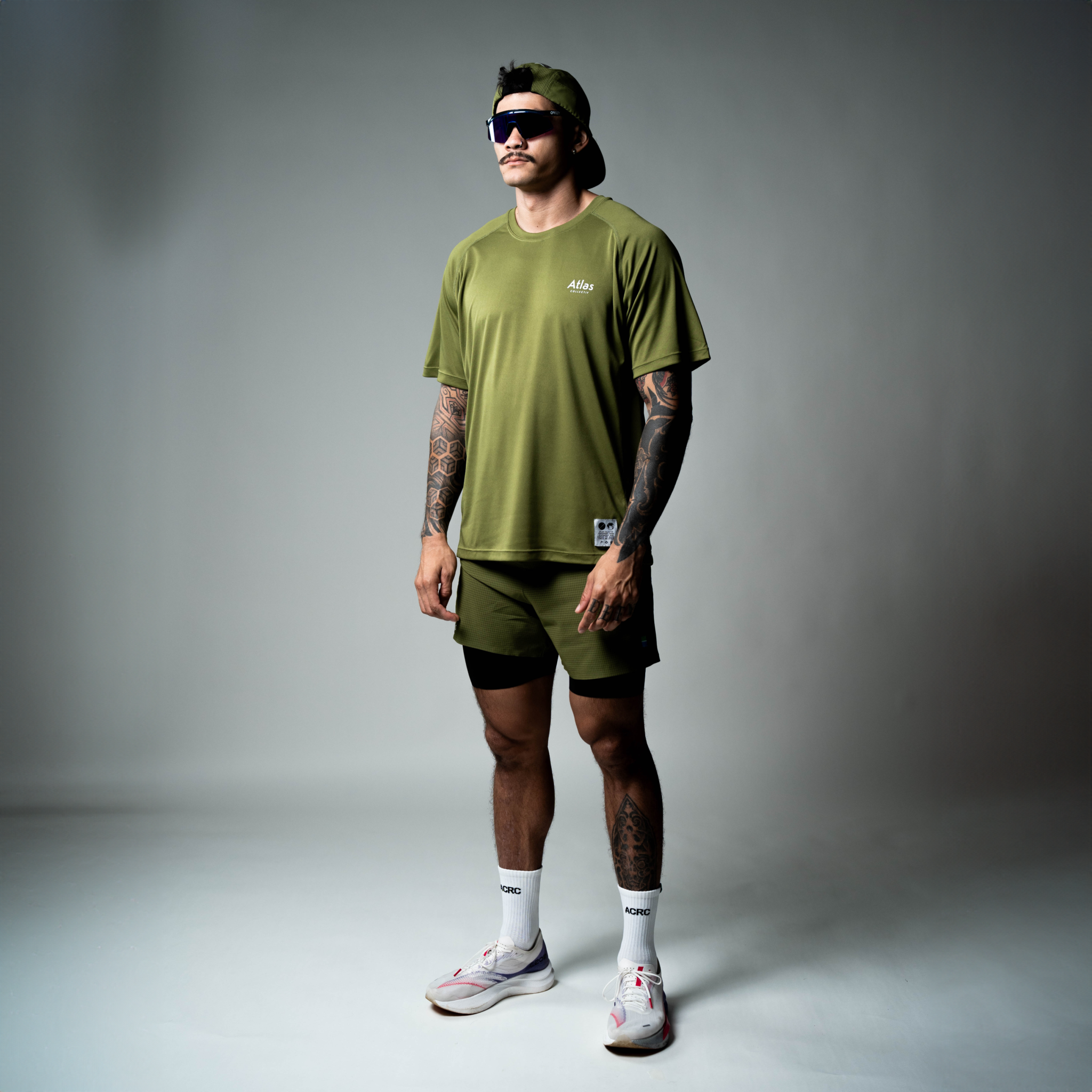 Performance 2 in 1 running shorts in olive green, tight fit, moisture-wicking, quick-drying, odor-resistant, made from recycled plastic.