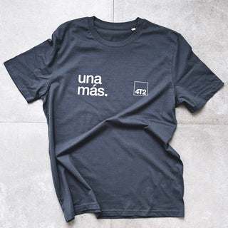 Unisex organic cotton tee with "una más." text, relaxed fit, dark color.