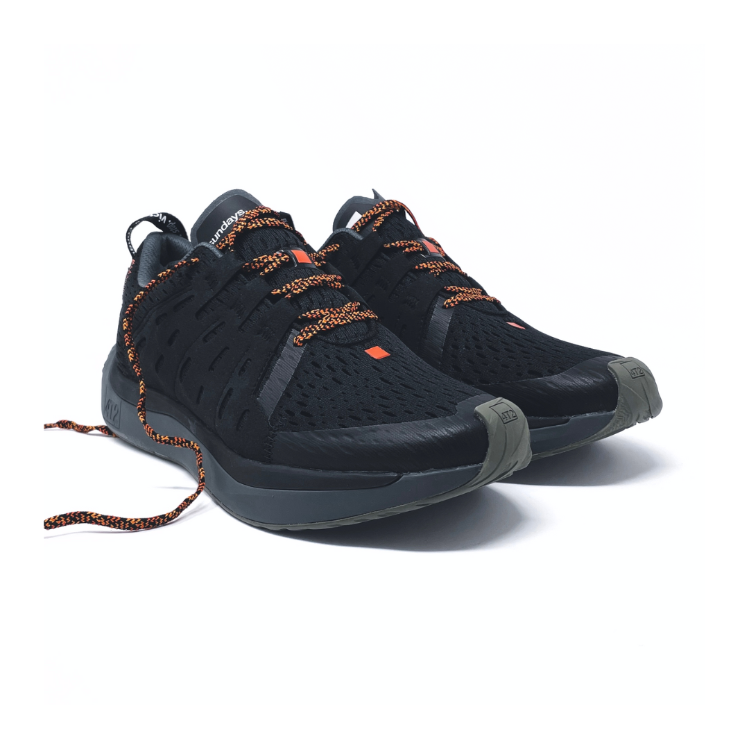 Black athletic shoes with orange accents, designed for comfort and support.