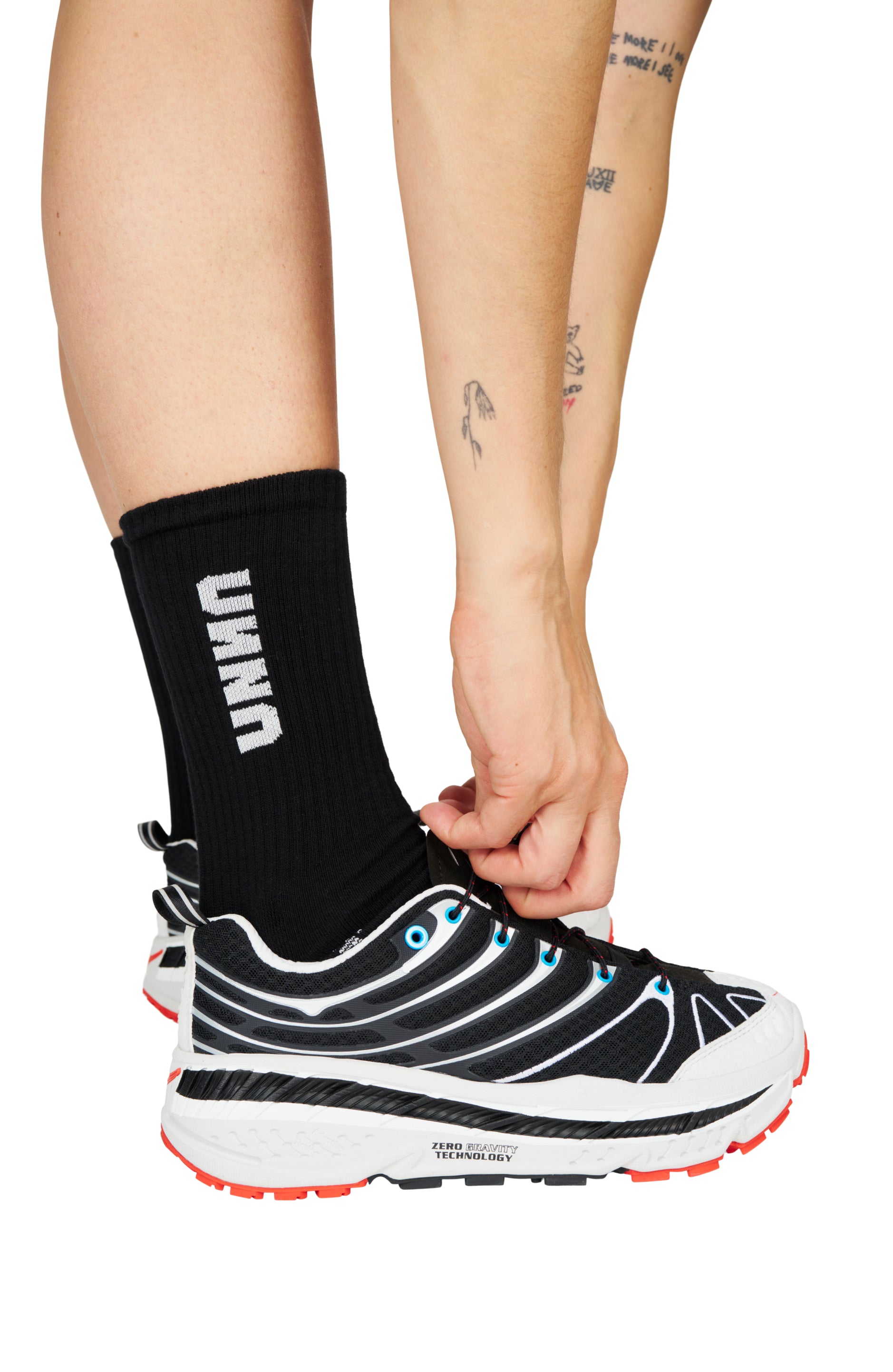 Black recycled running socks with UNNA logo, worn with running shoes.