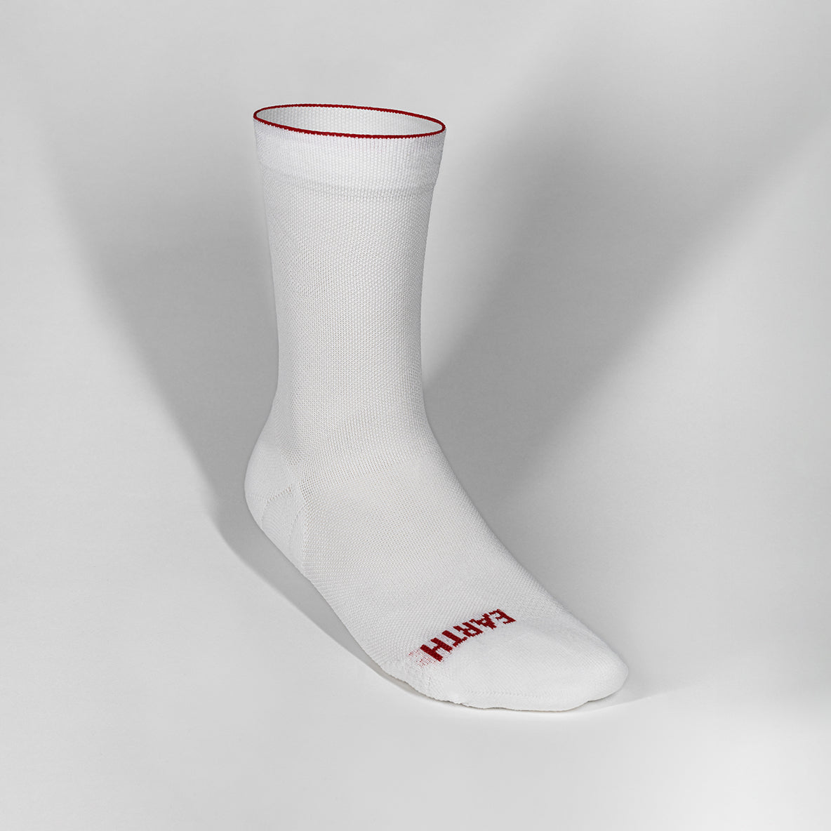 Ultralight white race day sock with red trim, breathable fibers, and compression fit.