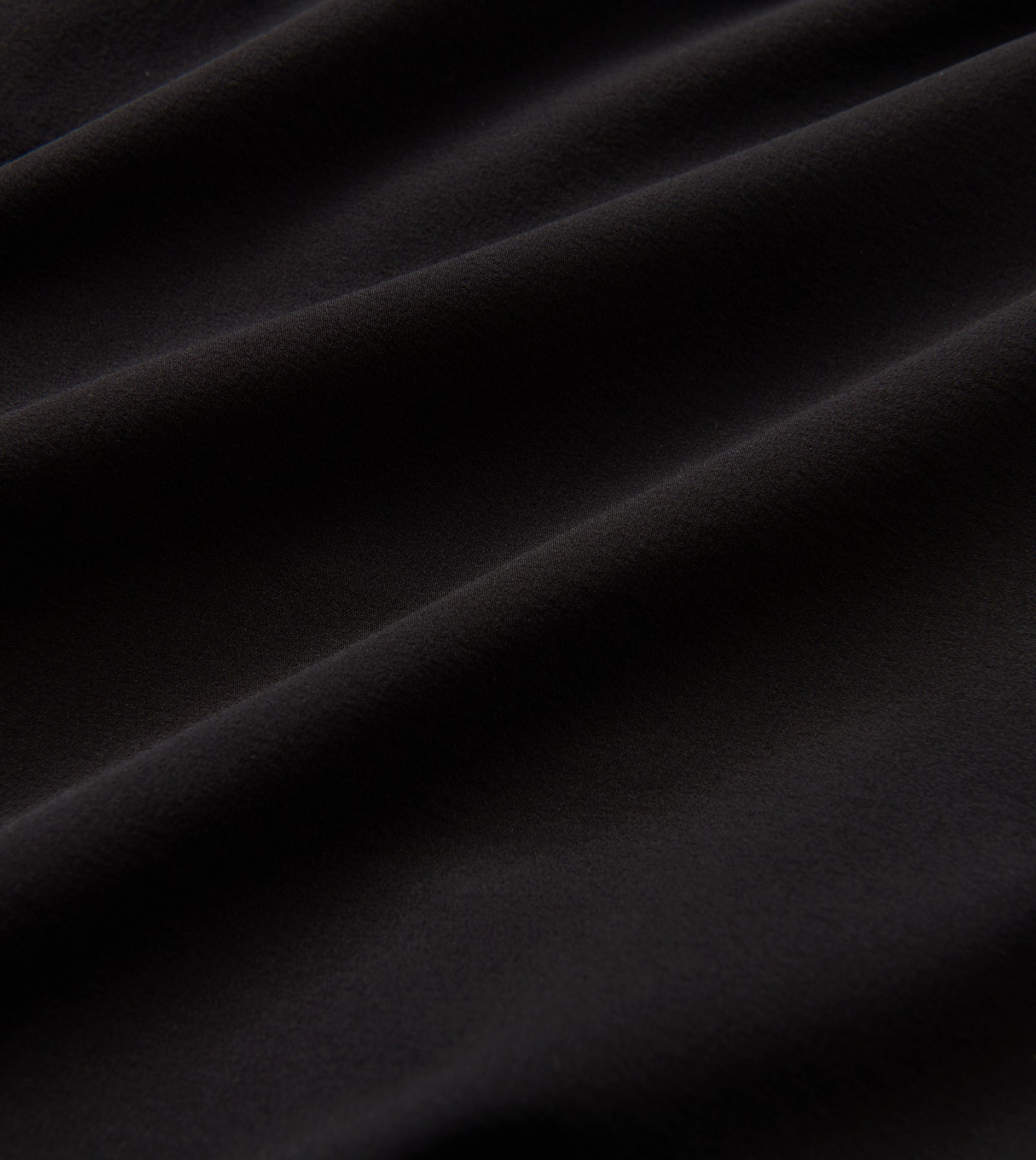 Close-up of black fabric texture for Alta Shorts 5" with 4-way stretch and moisture-wicking properties.