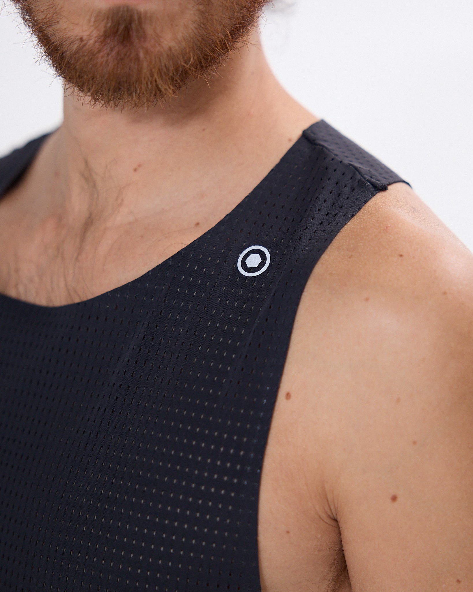 Koumori Training Singlet with breathable fabric and reflective logo for running.