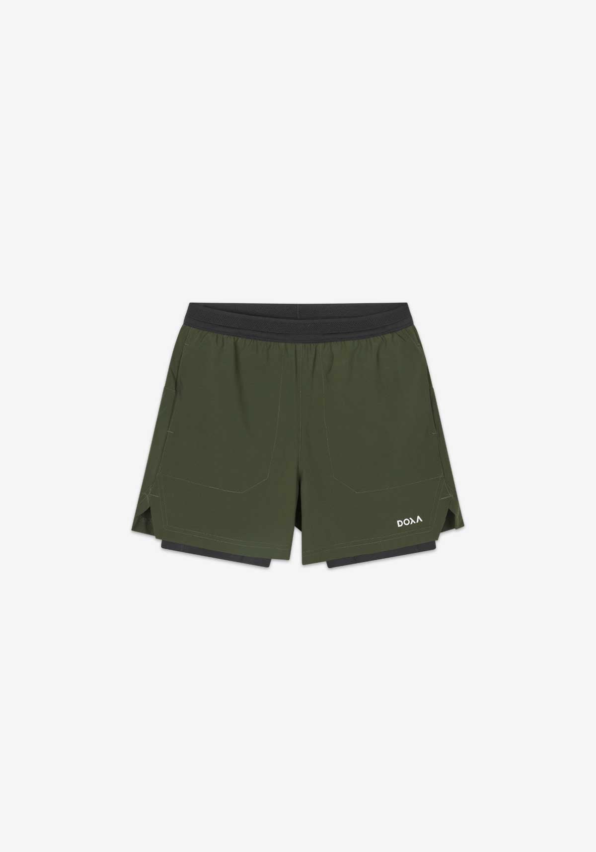 RERUN 2-1 SHORTS - Forest green unisex athletic shorts with inner tights, ventilated waistband, and multiple pockets.