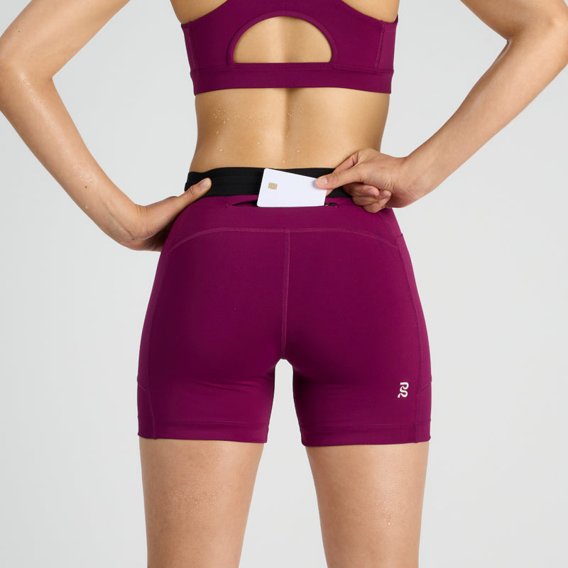 Stamina™ 5" women's compression shorts with zippered pocket and reflective logos.