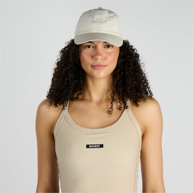 Cream Japanese nylon dad hat with "Bandit" embroidery, adjustable strap, designed for durability and water resistance.