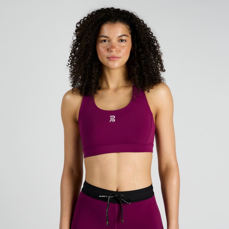 Stamina™ Scoop Neck Run Bra in purple, featuring versatile stretch and three pockets, worn by model.