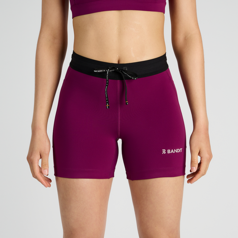 Stamina™ 5" women's compression shorts with pockets, reflective logos, and black waistband.