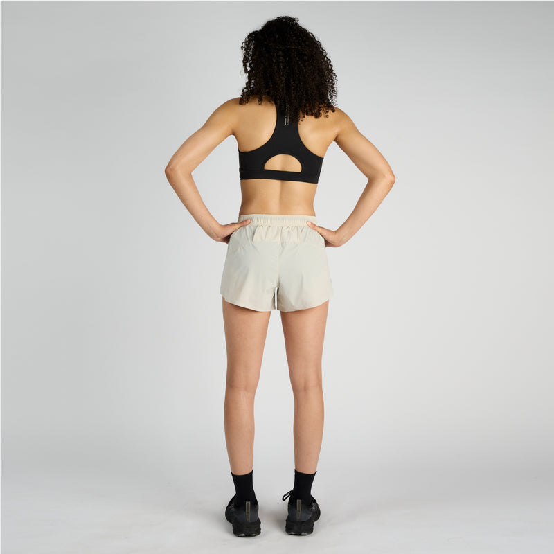 Vento™ 4" women’s training short with ruched waistband, curved hem, and functional drawcord in back view.