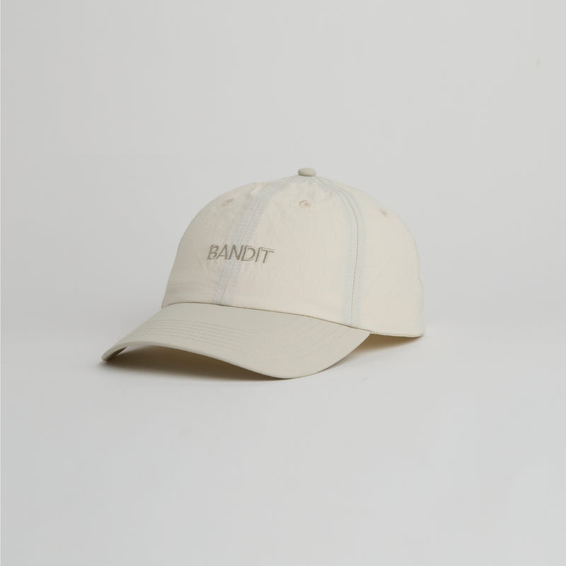 Cream Japanese Nylon Ripstop Dad Hat with embroidered "Bandit" wordmark, featuring adjustable webbing and water-resistant finish.
